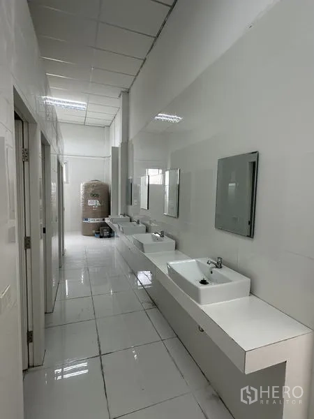 工厂 出租在Khlong Luang, Pathum Thani - 员工洗手区走廊，配多组洗手盆、镜子与白色瓷砖。