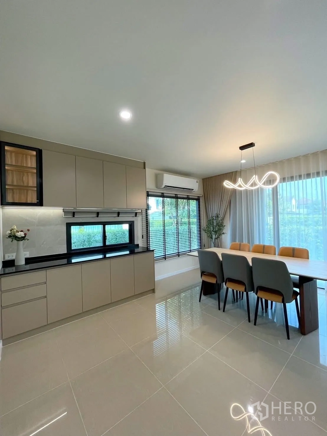 บ้านเดี่ยว for rent in Bang Phli, Samut Prakan - ครัวมินิมัลลิสต์ ตู้บิลต์อินสีเบจ ท็อปหินสีดำ และโต๊ะทานอาหารหกที่นั่งริมหน้าต่าง