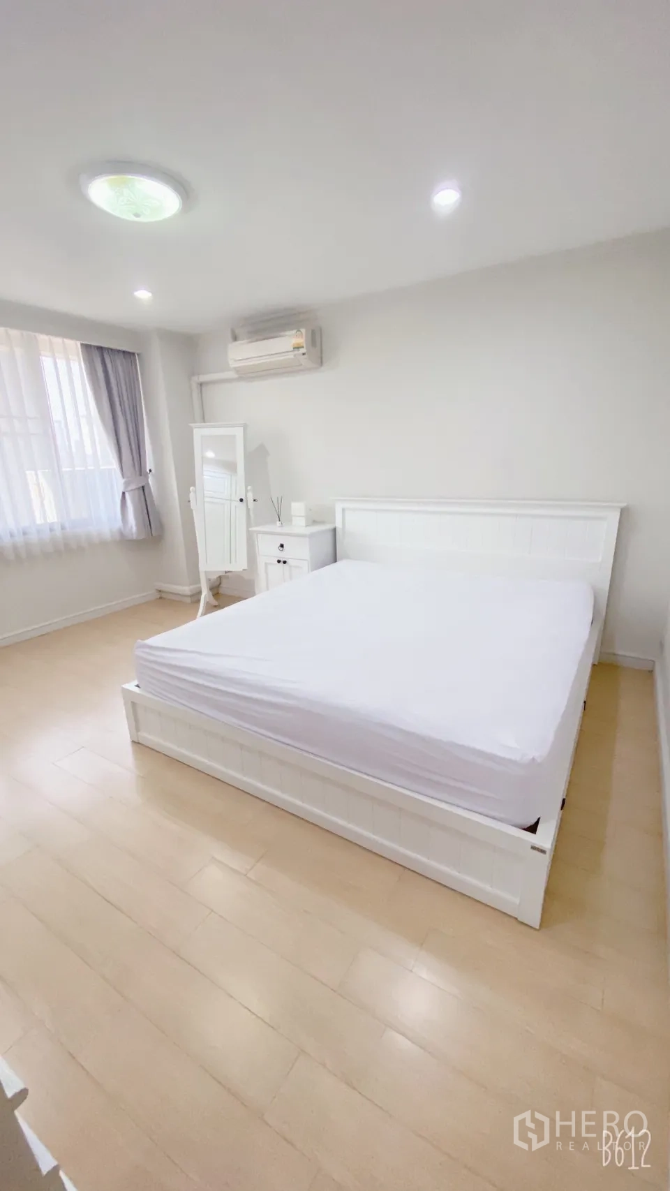คอนโด ให้เช่าในWatthana, Bangkok - ห้องนอนรับแสงธรรมชาติ เตียงสีขาว โต๊ะหัวเตียง กระจกยืน และผ้าม่านโปร่ง