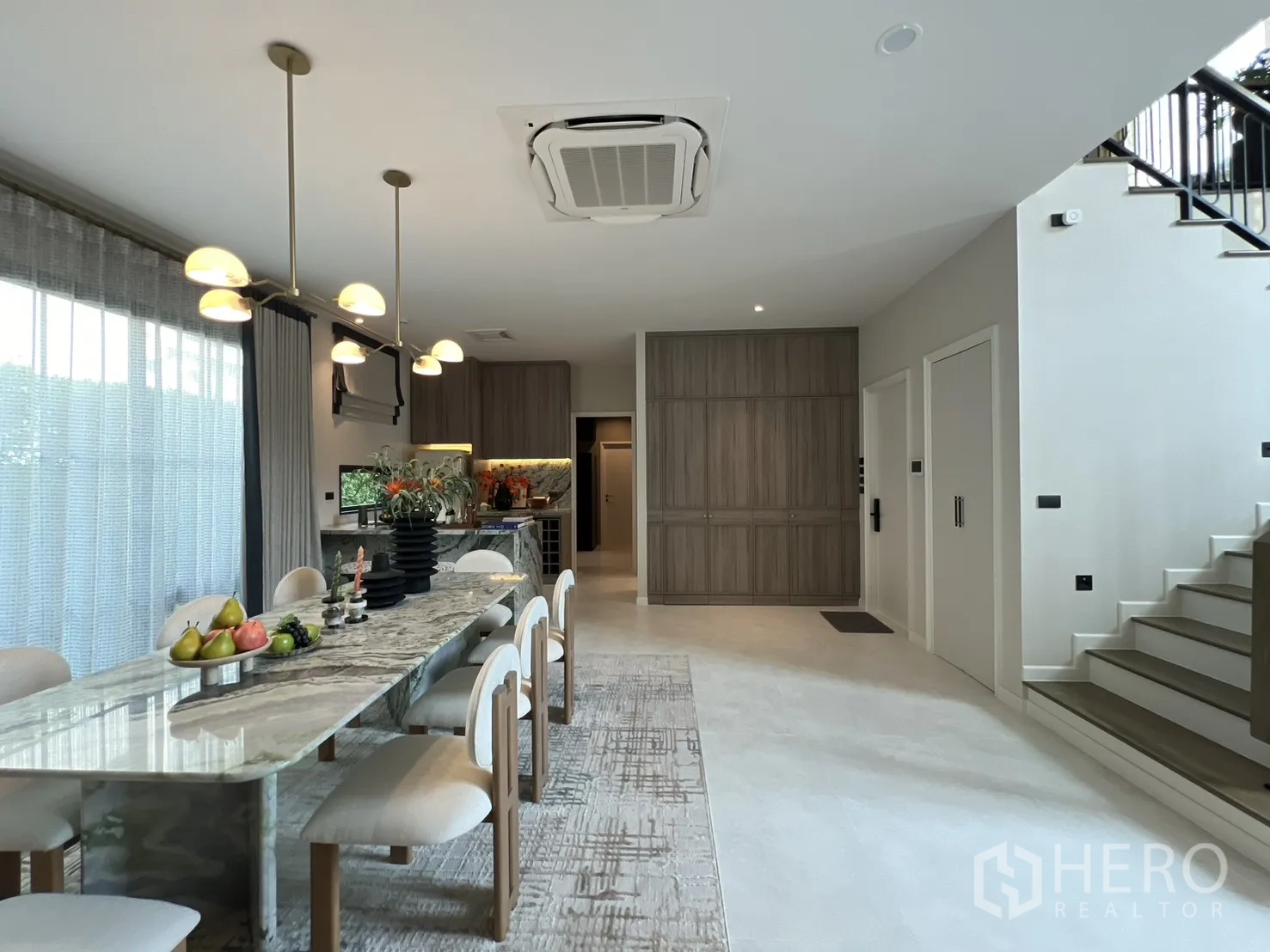 独栋房屋 for rent in Bang Phli, Samut Prakan - 开放式餐厨区，长款大理石餐桌、吊灯与内置柜体。