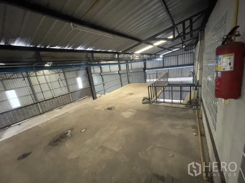 Warehouse for rent in Prawet, Bangkok - Mezzanine corner with safety railing and fire extinguisher.