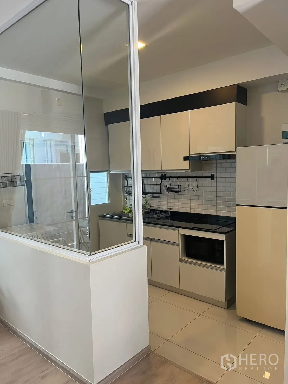 联排别墅 for rent in Prawet, Bangkok - 玻璃分隔的厨房，设橱柜与冰箱。