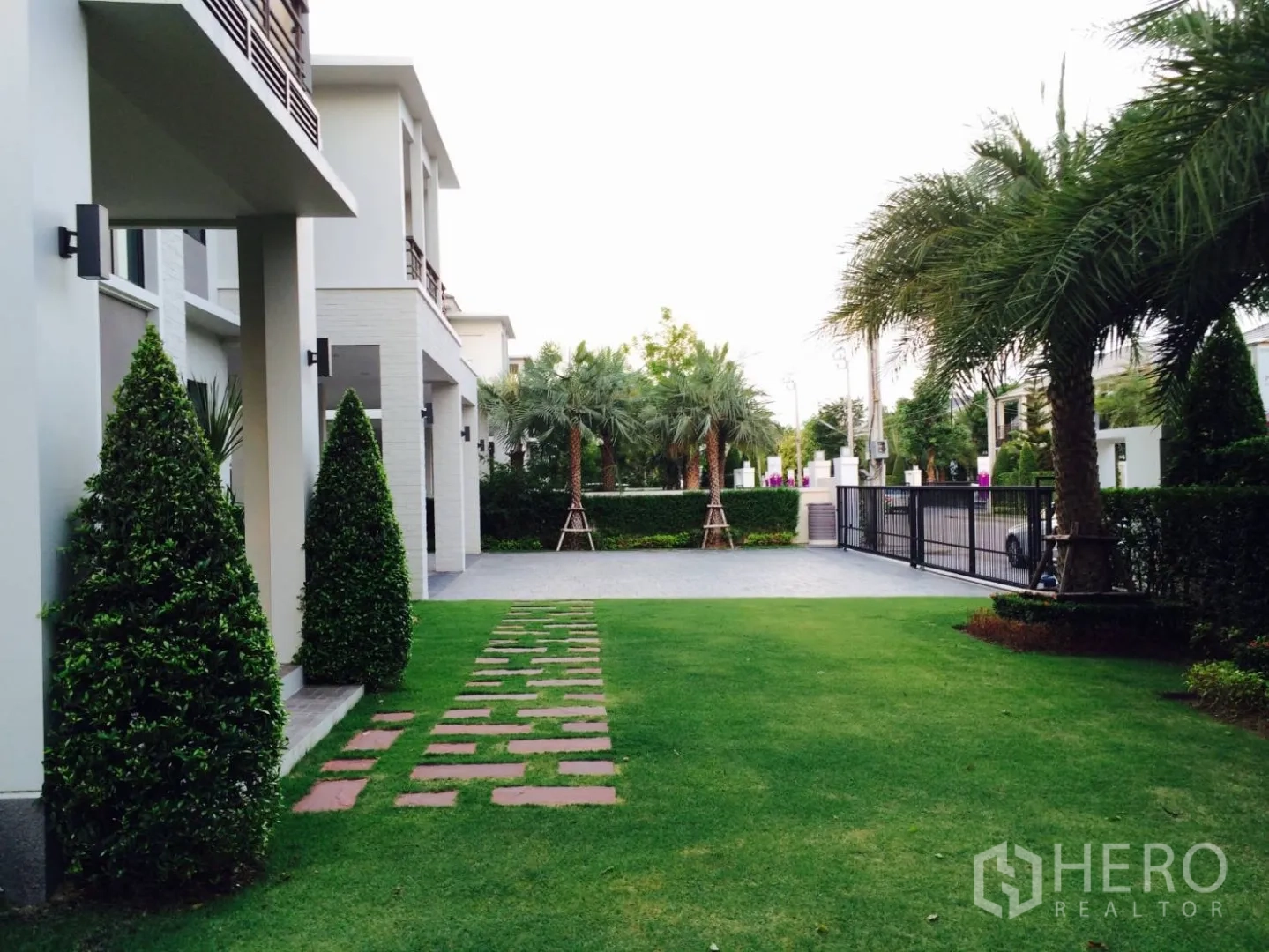 Detached House for sale in Lat Krabang, Bangkok - Front garden with stepping stones leading to the gated entrance and driveway.