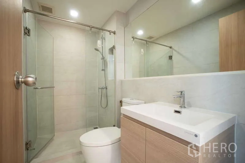 Condominium for rent - Contemporary bathroom with glass shower enclosure and wide vanity.