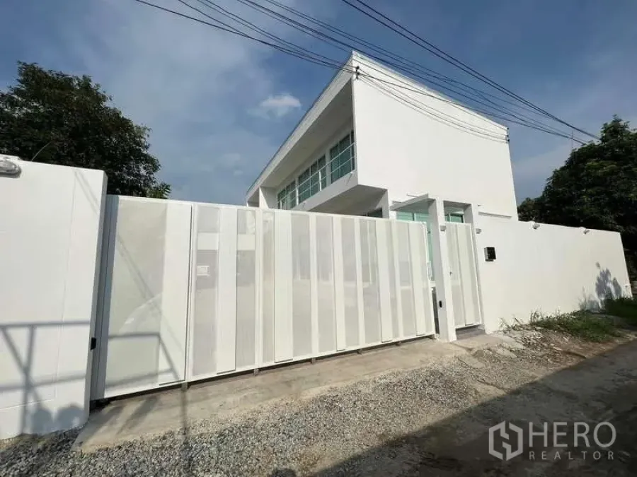 Detached House for rent in Lat Krabang, Bangkok - Secure modern sliding gate and high privacy wall in front of the two‑storey house.