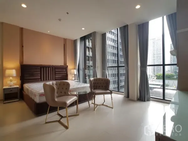 公寓 出租在Pathum Wan, Bangkok - 转角卧室配落地窗，城市景观与小型会客区