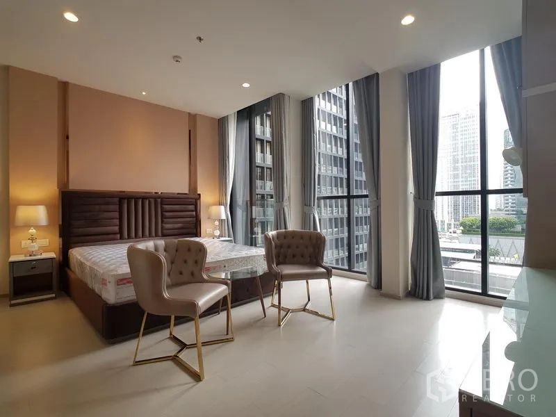 公寓 出租在Pathum Wan, Bangkok - 转角卧室配落地窗，城市景观与小型会客区
