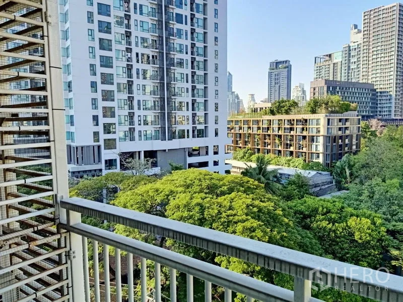 Condominium for rent in Khlong Toei, Bangkok - Balcony view of neighboring modern condominiums and treetops in the Thonglor area.