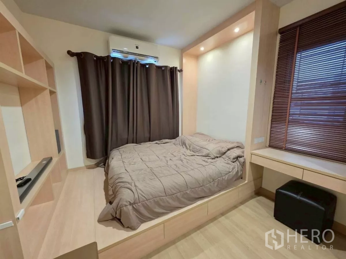 Detached House for rent or sale in Samut Prakan - Bedroom with built-in bed platform, desk and dark curtains.