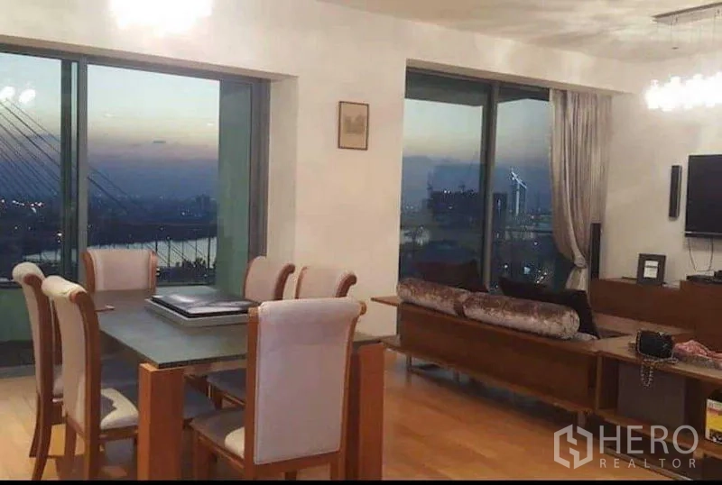 คอนโด ให้เช่าหรือขายในYan Nawa, Bangkok - ห้องนั่งทานยามค่ำ วิวเมืองและแม่น้ำผ่านช่องหน้าต่างกว้าง