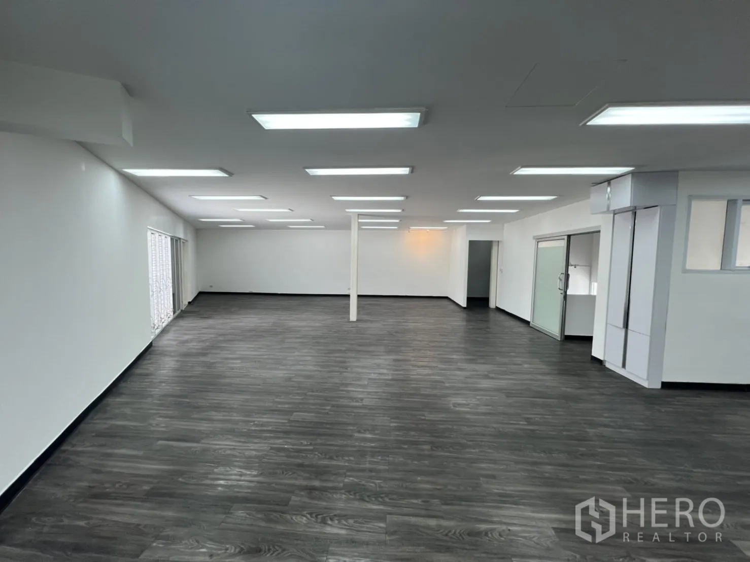 Retail Space for rent in Sathon, Bangkok - Large white retail floor with gray vinyl and sliding doors on one side.