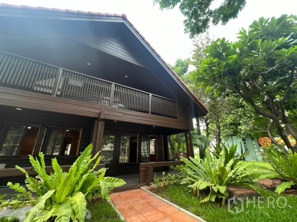 带办公室的家 出租在Suan Luang, Bangkok - 两层木质家用办公楼，带阳台、砖路与花园树木。