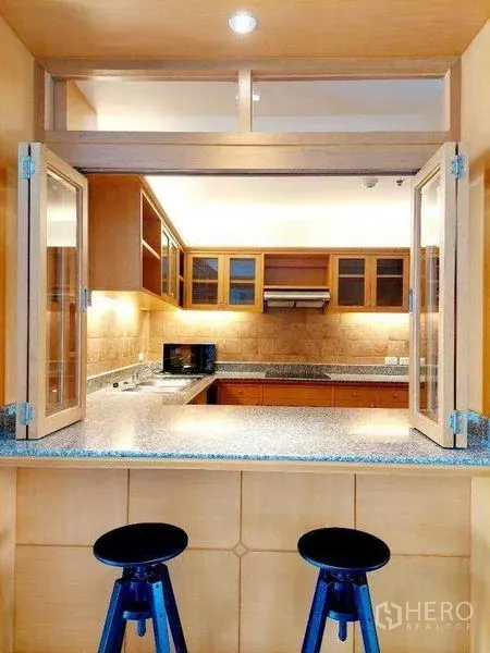 Apartment for rent - Breakfast bar with folding window opening to a U-shaped kitchen and two bar stools.