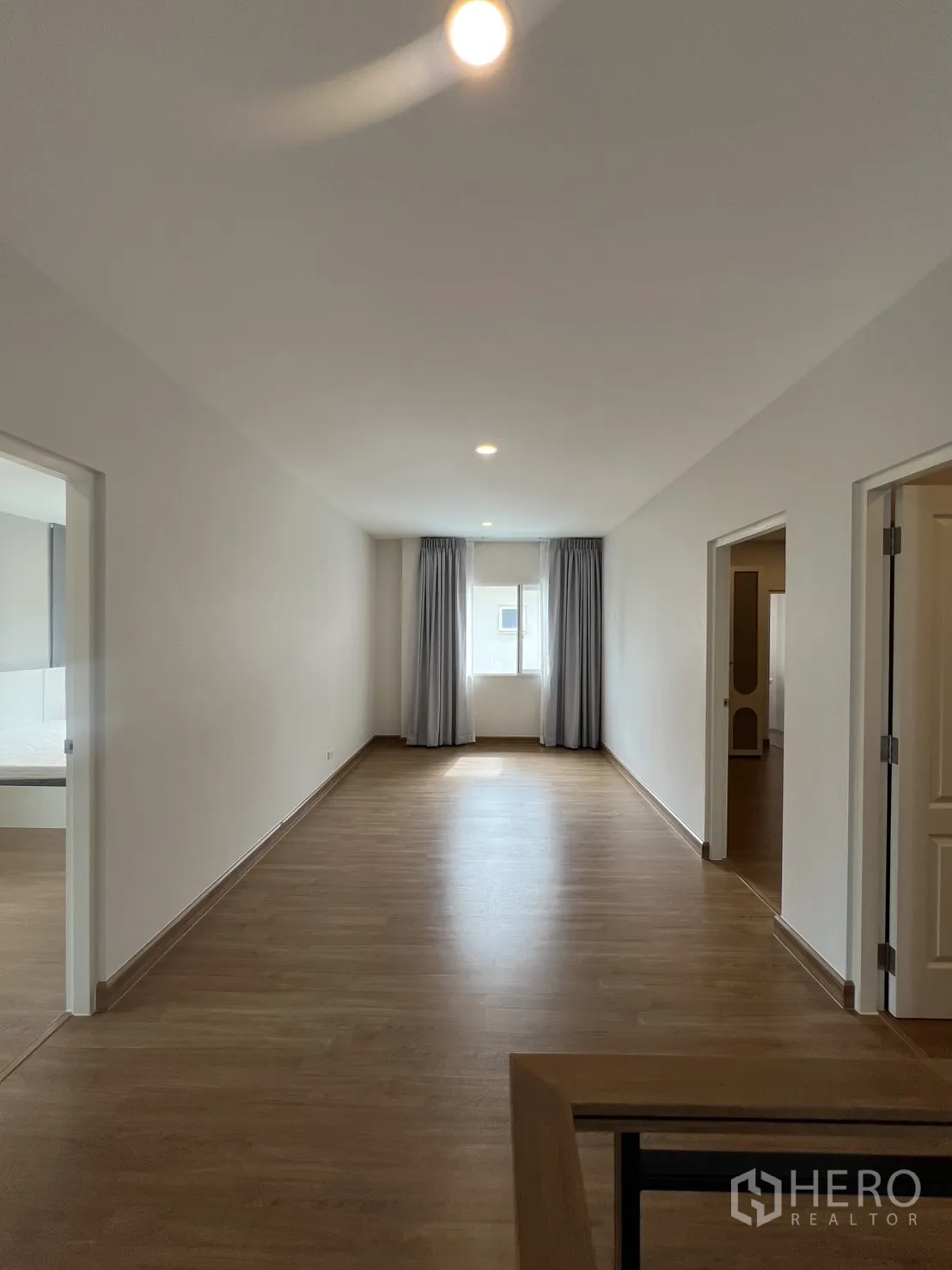 独栋房屋 for rent in Lat Krabang, Bangkok - 二层过道铺木纹地板，嵌灯与带窗帘的窗户。