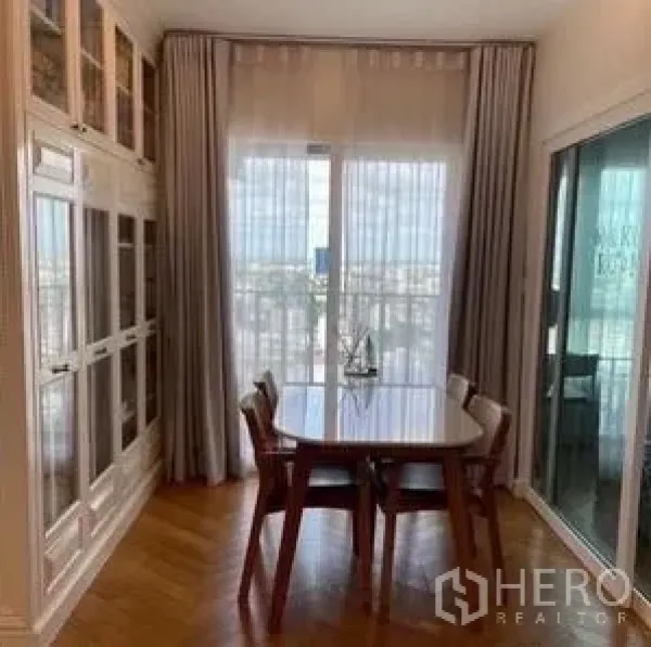 Condominium for rent or sale - Compact dining area by the balcony with wood flooring, tall cabinets, and filtered daylight.