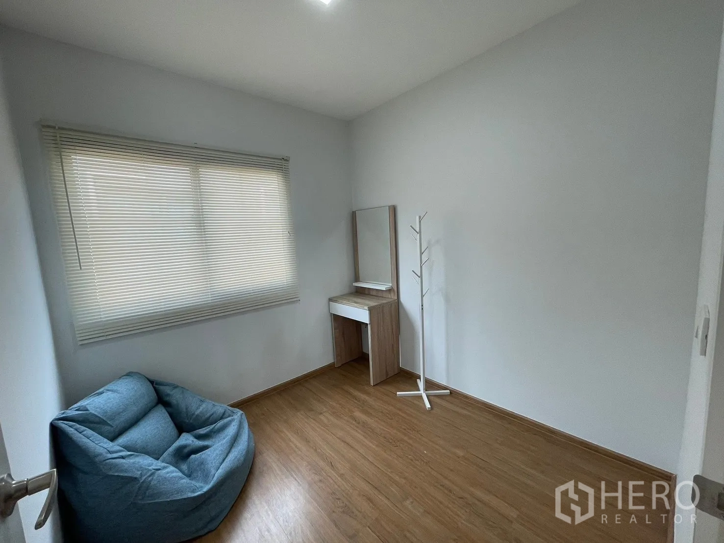 ทาวน์เฮาส์ for rent in Bang Phli, Samut Prakan - ห้องนอนอเนกประสงค์สว่าง หน้าต่างบานใหญ่ มู่ลี่สีขาว พื้นไม้ เก้าอี้บีนแบ็กสีน้ำเงิน และโต๊ะเครื่องแป้ง