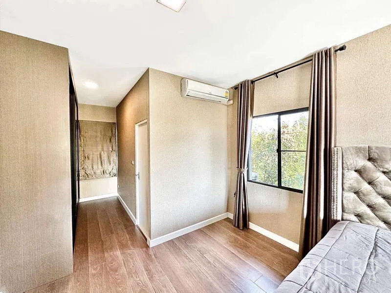 Detached House for sale in Bang Phli, Samut Prakan - Bedroom corridor with air-conditioning unit and window overlooking greenery.