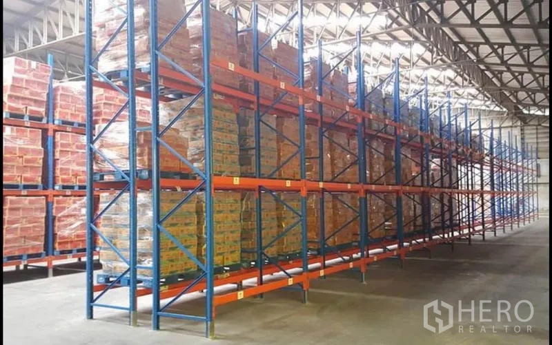 Warehouse for rent or sale - Tall blue and orange pallet racking fully loaded inside the warehouse.