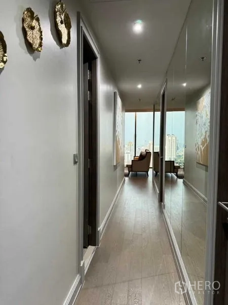 คอนโด ให้เช่าในWatthana, Bangkok - โถงทางเดินสว่าง ผนังกระจกเงา ปลายทางเห็นมุมนั่งเล่นและวิวเมือง.