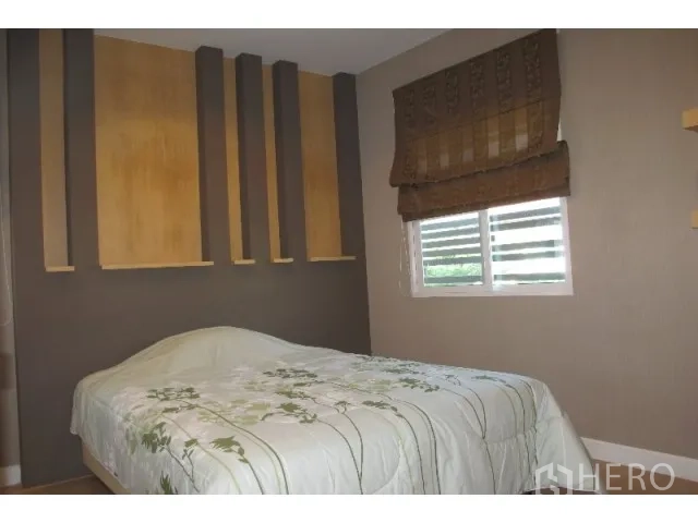 Detached House for rent in Saphan Sung, Bangkok - Cozy bedroom with decorative accent wall, window blinds, and double bed.