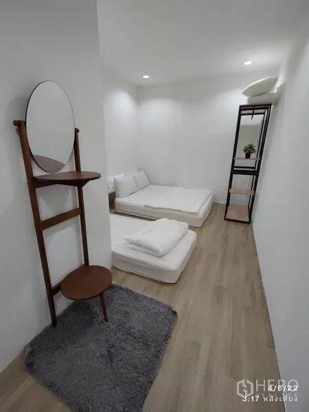 Home Office for rent - Narrow bedroom with two floor mattresses, freestanding vanity mirror and rug.