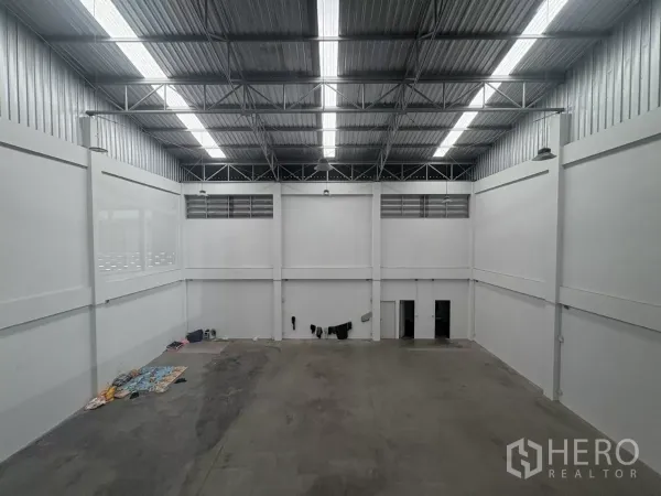 Factory for rent in Phra Samut Chedi, Samut Prakan - View from mezzanine overlooking wide warehouse space and access doors.