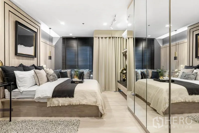 Condominium for sale in Pathum Wan, Bangkok - Main bedroom with mirrored wardrobes, neutral tones and blackout blinds.