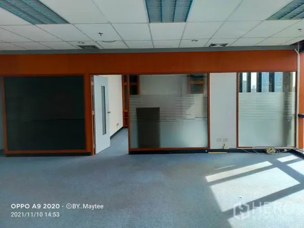 Office Space for rent in Watthana, Bangkok - Open-plan office near BTS Asok with frosted glass partitions, wood frames, blue carpet and grid ceiling lighting.