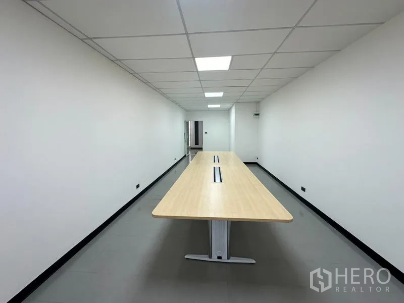 Office Space for rent - Boardroom view centered on a long meeting table with clean white walls.