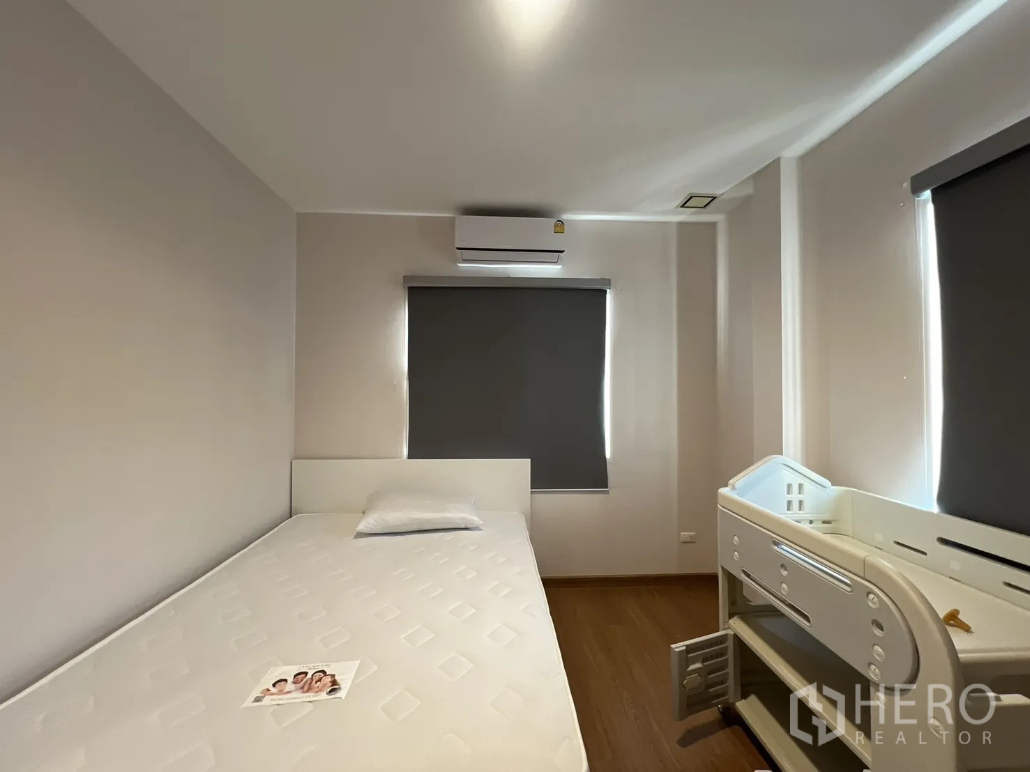 Detached House for rent in Bang Kapi, Bangkok - Cozy bedroom with bed and baby crib under blackout blinds.