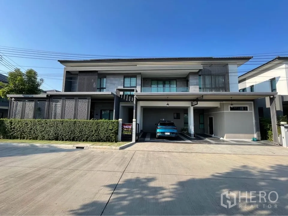 独栋房屋 for rent or sale in Bang Phli, Samut Prakan - 现代两层独栋住宅，前院绿篱与宽敞有顶车位。