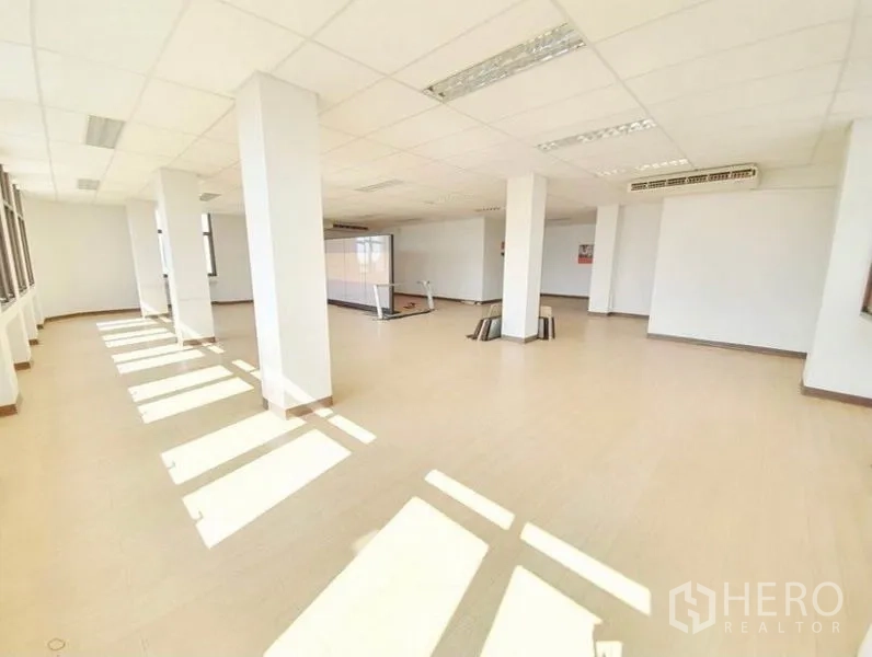 办公空间 出租在Bang Na, Bangkok - 邦那采光充足的开放式办公层，设立柱、大窗、木纹地板与吊顶灯。