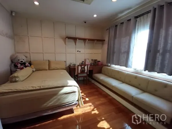 独立式住宅 出售在Phra Khanong, Bangkok - 客卧配备书桌、长沙发与木地板，自然采光充足。