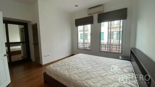联排别墅 出租在Wang Thonglang, Bangkok - 采光良好的卧室，双人床、空调和两扇窗。