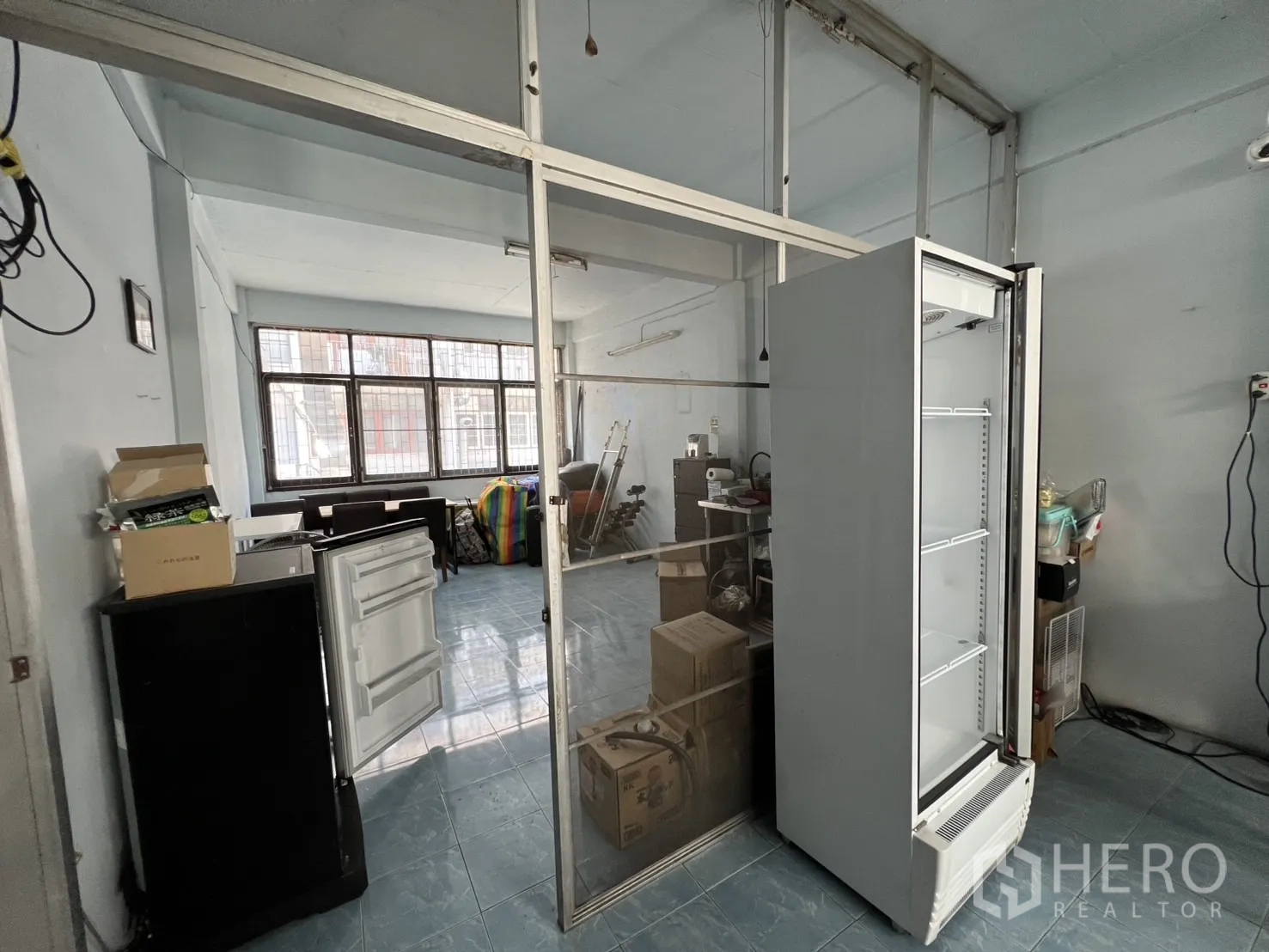 店屋 出租或出售 - 楼层空间带玻璃墙和敞开展示冰柜，靠近窗户。
