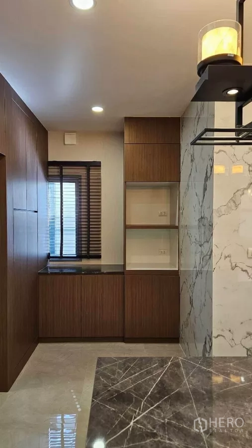 Detached House for rent in Bang Phli, Samut Prakan - Pantry space with marble island, wood cabinetry and window blinds.