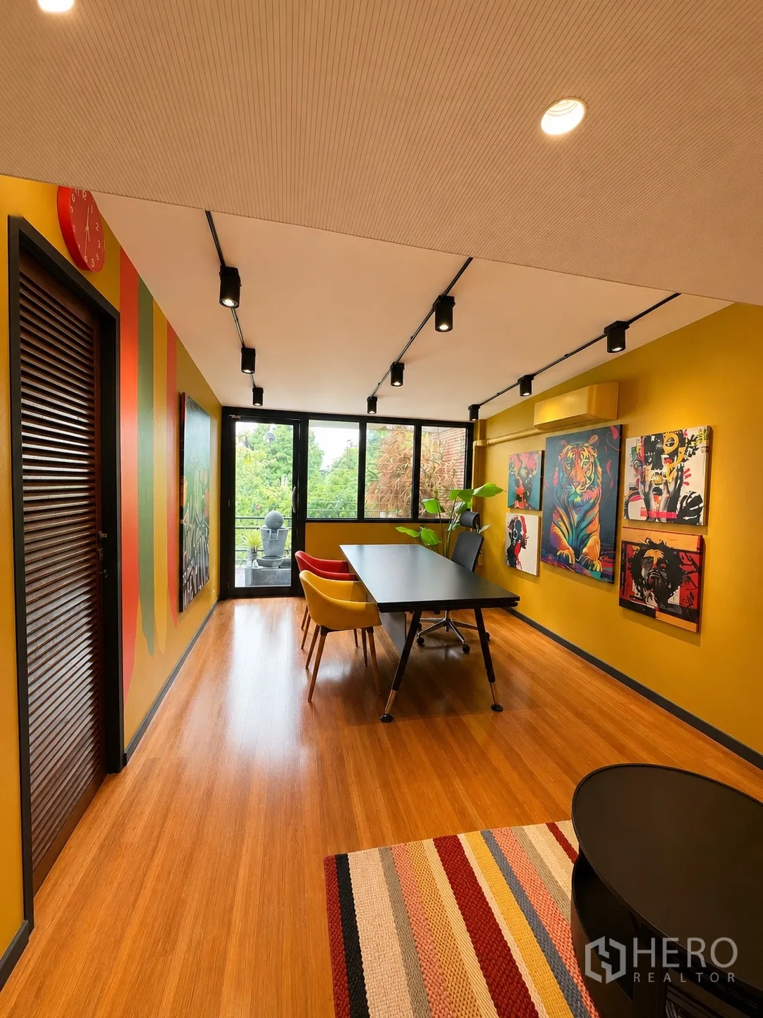 Office Space for rent in Phaya Thai, Bangkok - Creative room with artwork, meeting table and chairs, and floor-to-ceiling windows.