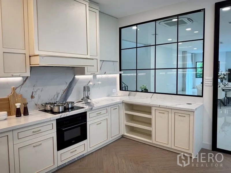 Detached House for rent or sale - L-shaped gourmet kitchen with marble backsplash, built-in oven, and a glass partition.