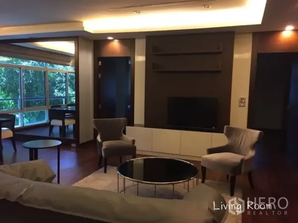 คอนโด ให้เช่าในSathon, Bangkok - ห้องนั่งเล่นโทนอุ่น ผนังทีวี เก้าอี้นวม และโต๊ะกลาง พื้นไม้จริง