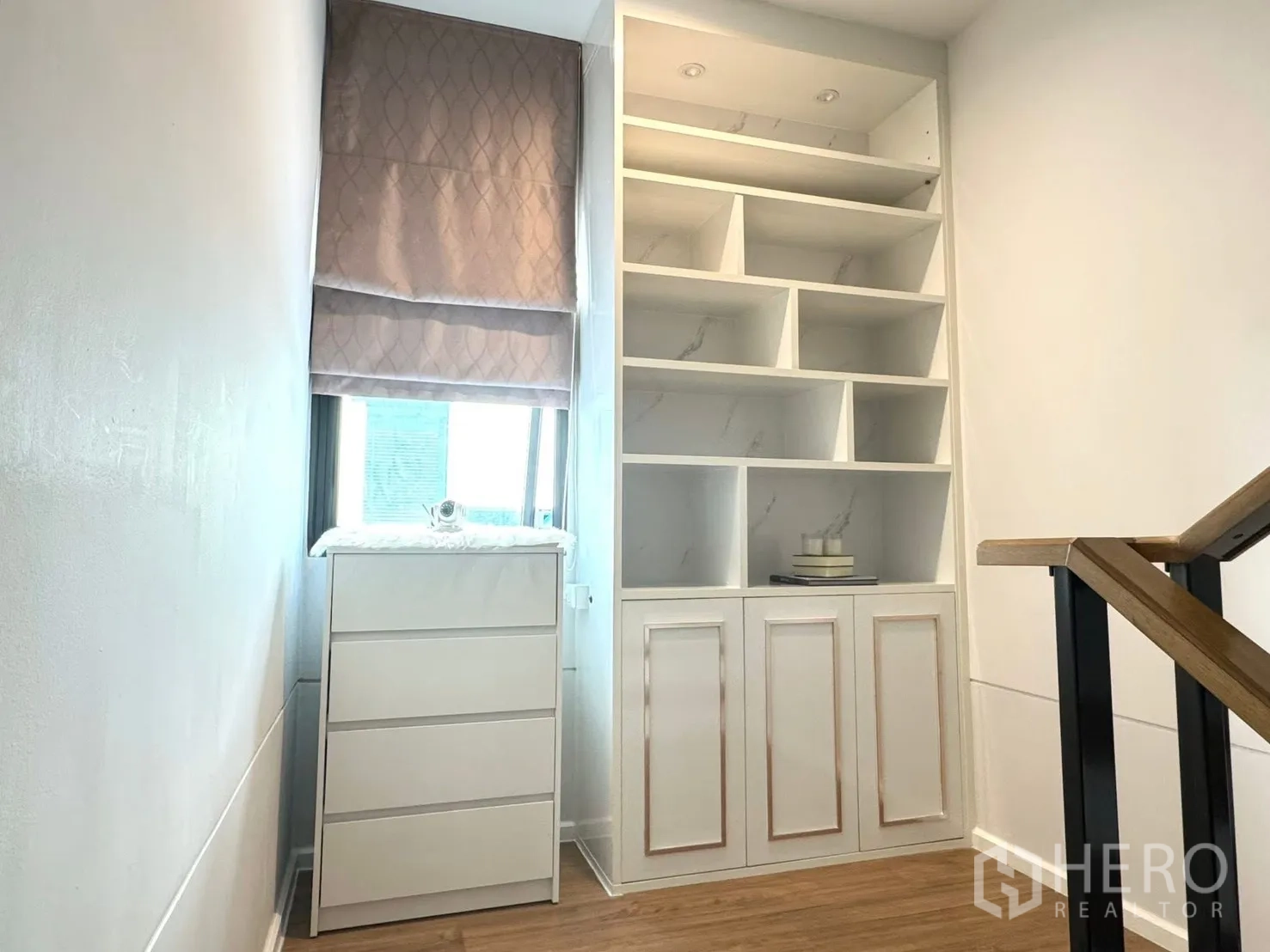Townhouse for rent in Saphan Sung, Bangkok - Stair landing with built-in white shelving and drawer unit.