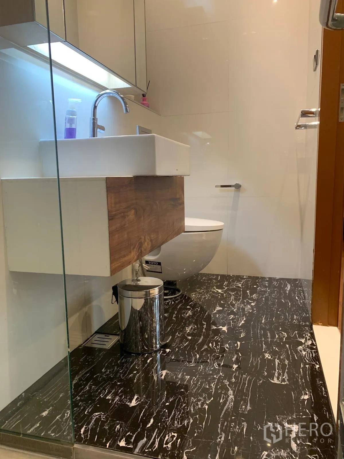 Condominium for sale in Khlong Toei, Bangkok - Bathroom with square basin, wall‑hung toilet and black marble floor.
