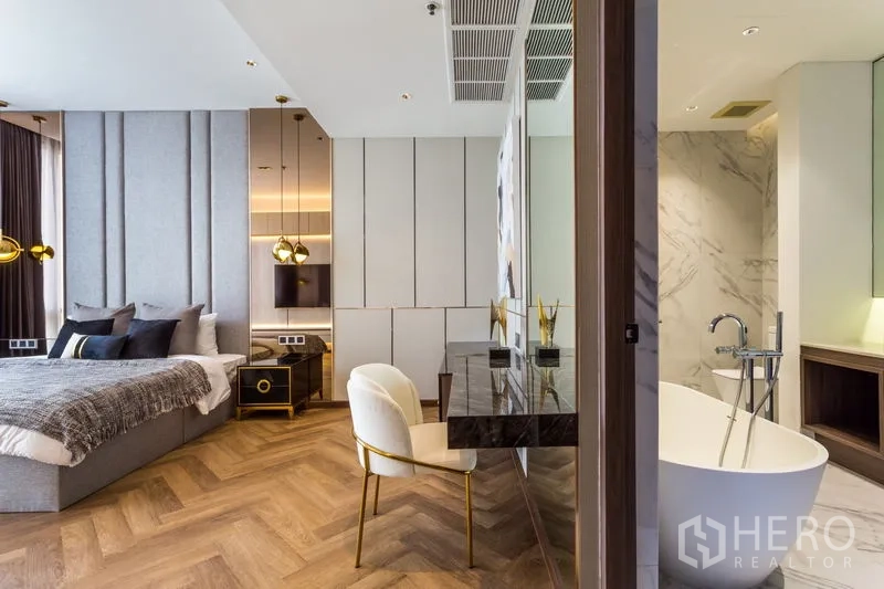 Condominium for rent in Khlong Toei, Bangkok - Master suite featuring herringbone floors and ensuite with freestanding tub and marble walls.