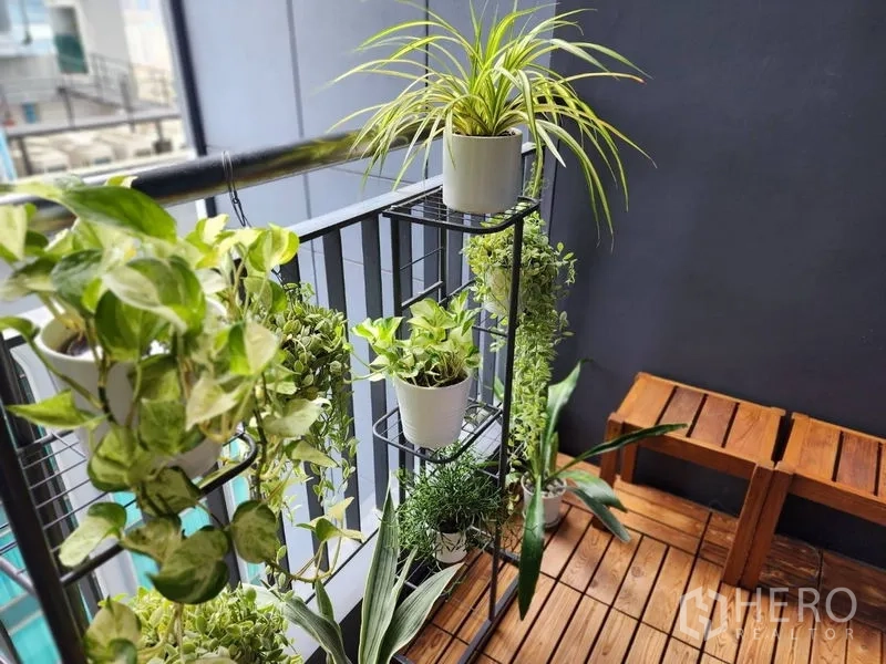 Condominium for rent in Watthana, Bangkok - Private balcony with wooden decking, bench seating and potted green plants.