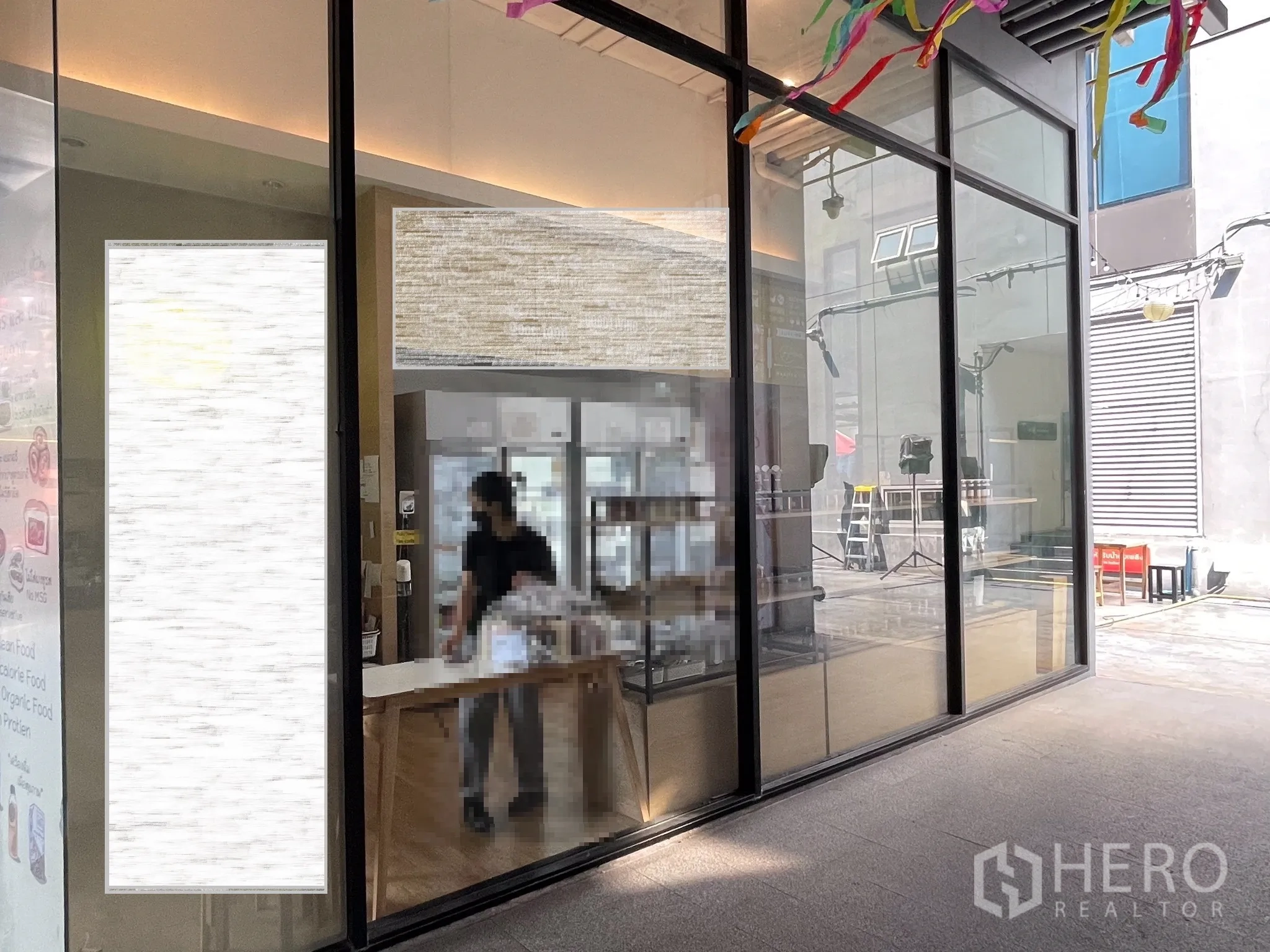 Retail Space for rent in Khlong Toei, Bangkok - Interior retail area with long glass facade, display counter, and warm lighting.