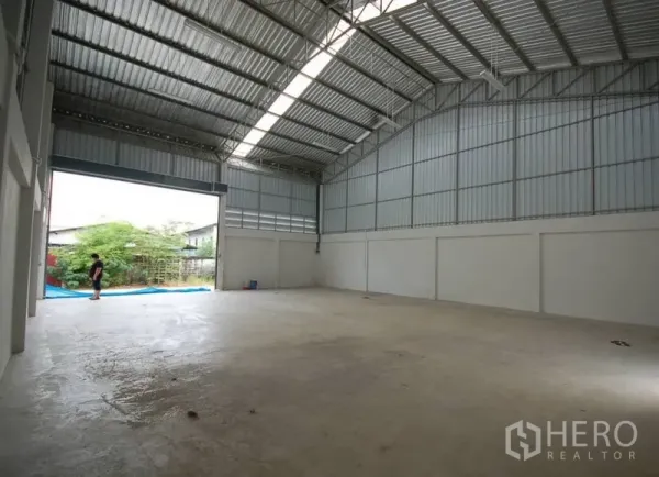คลังสินค้า ให้เช่าในNonthaburi - ภายในโกดังโล่ง เพดานเมทัลชีทสูง มีแผงรับแสงธรรมชาติและประตูม้วนขนาดใหญ่