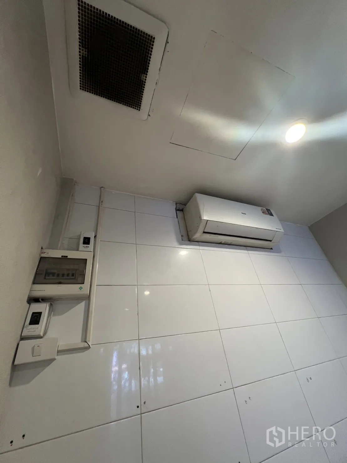 Retail Space for rent in Watthana, Bangkok - Ceiling detail showing split air conditioner, recessed lighting, ventilation grille, and electrical panel in the Sukhumvit retail space.
