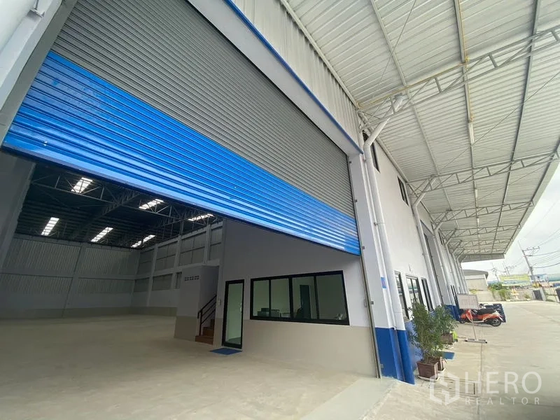 Warehouse for rent in Pathum Thani - Entrance bay with raised roller door, office windows, and a covered loading area.