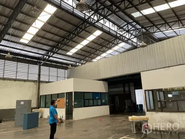 Warehouse for rent in Prawet, Bangkok - Expansive warehouse hall featuring high ceilings, skylights, and administrative office boxes.