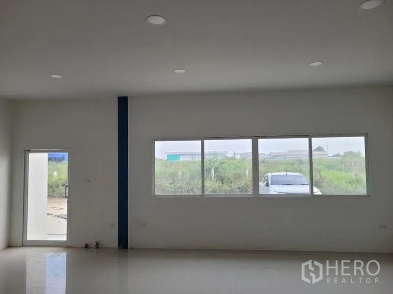 Factory for rent or sale in Khlong Luang, Pathum Thani - Office room with large windows overlooking green surroundings in the industrial area.