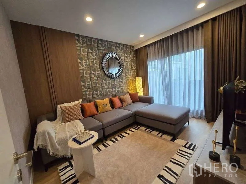 บ้าน ให้เช่าในBang Kapi, Bangkok - ห้องเอนกประสงค์พร้อมโซฟาแอลตัวใหญ่ พรมลาย และประตูกระจกบานเลื่อน